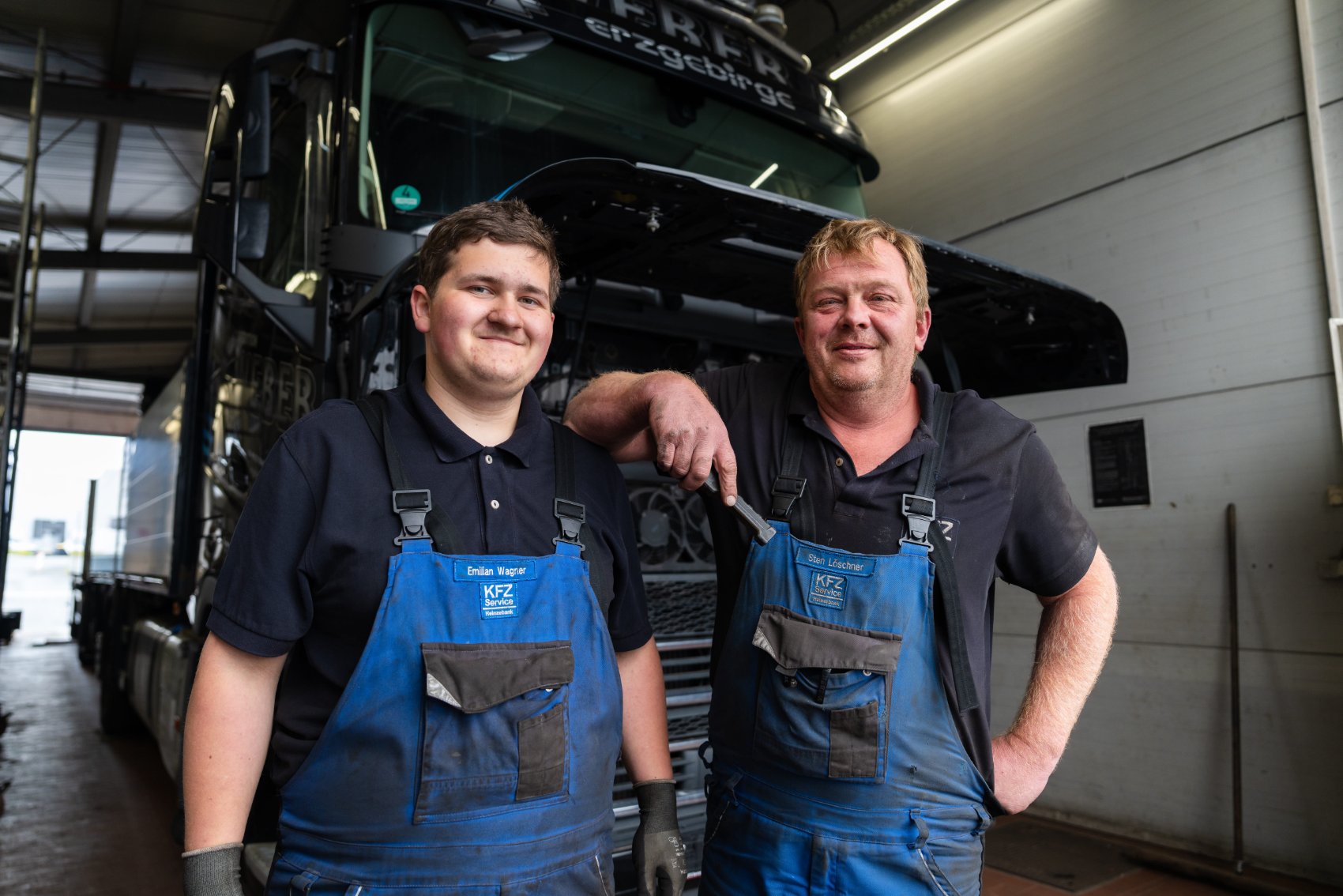 Azubi und Mechaniker am LKW in der Werkstatt